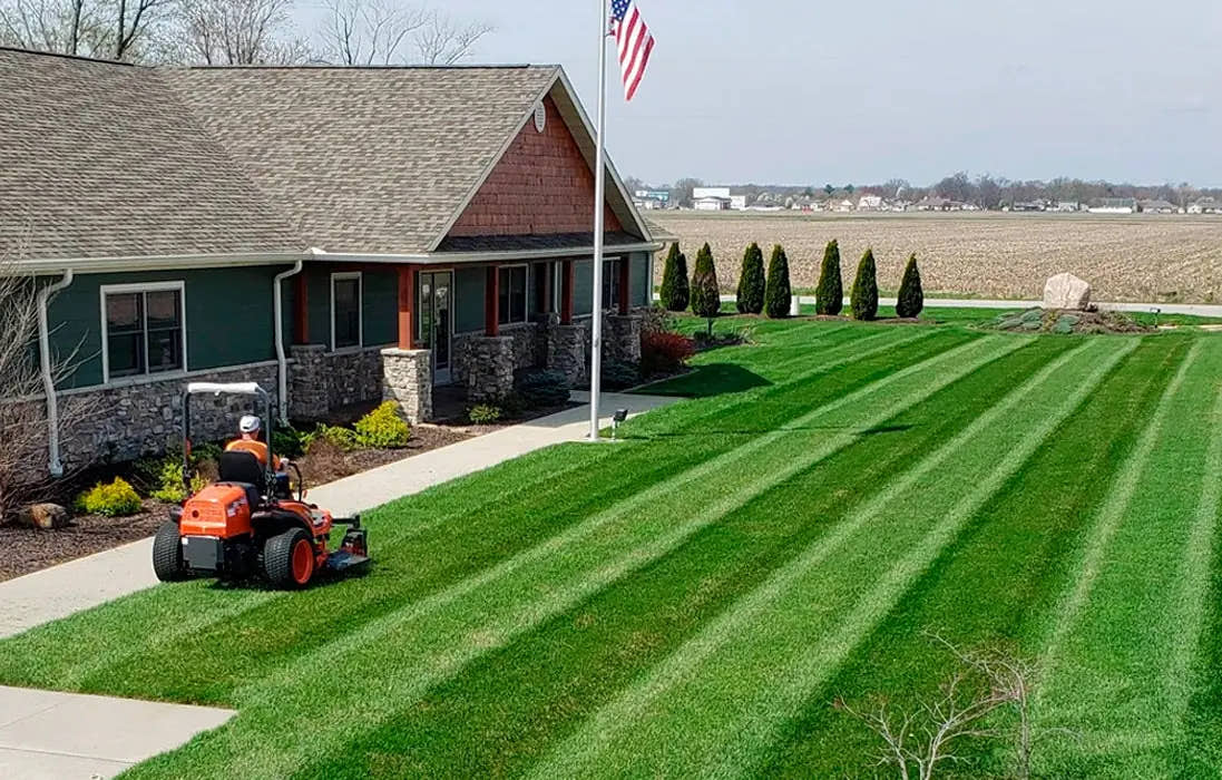 Tractor and striped lawn outside a home